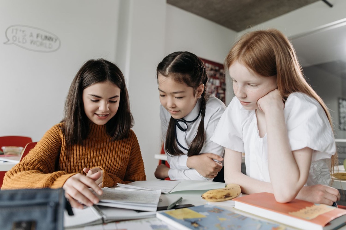 Ragazze che studiano insieme sui libri in aula