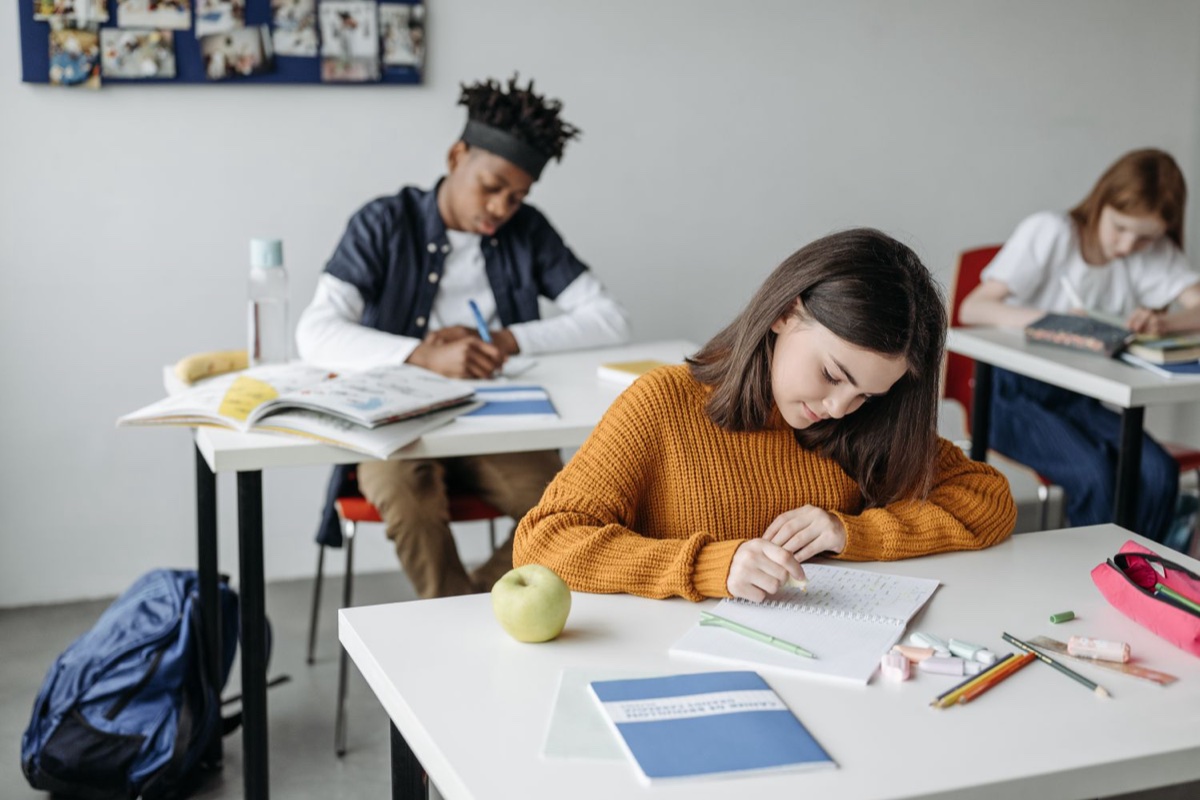 Ragazza che studia al banco durante la lezione
